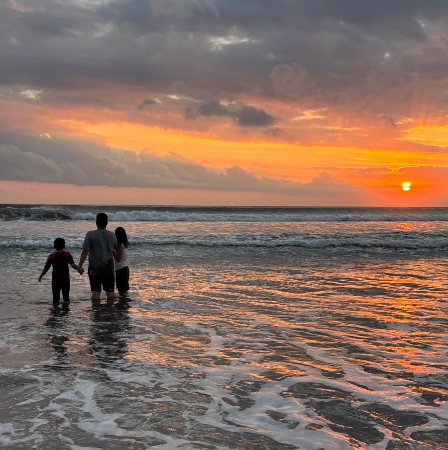 Atardecer en Legian Beach con personas caminando por la orilla en Kuta, Bali