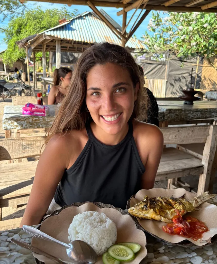 Comiendo pescado a la parrilla con arroz en un restaurante local de Pink Beach, Lombok, Indonesia.