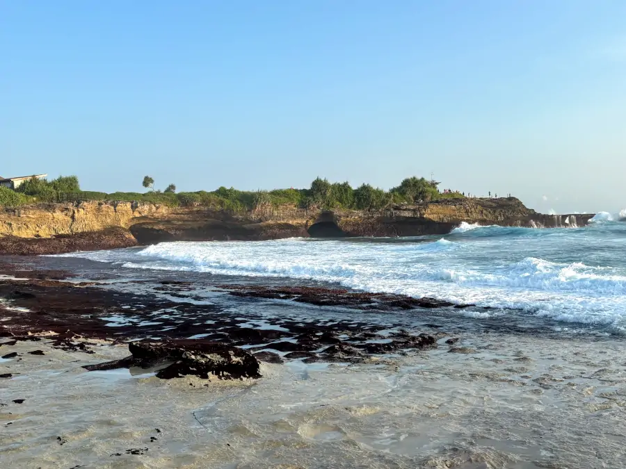 Sandy Bay en Nusa Lembongan, con acantilados bajos, rocas en la orilla y olas rompiendo con fuerza