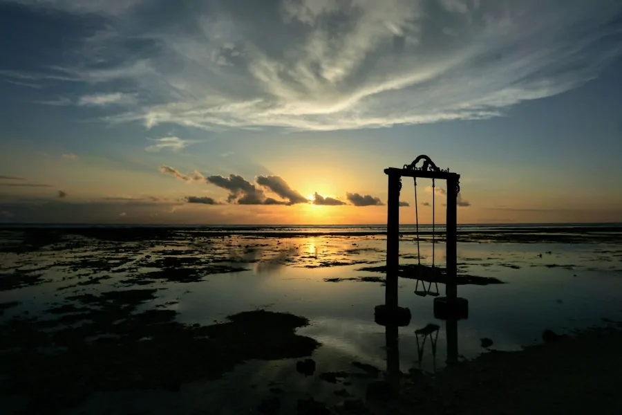 Atardecer en Gili Trawangan con columpio en el mar y marea baja