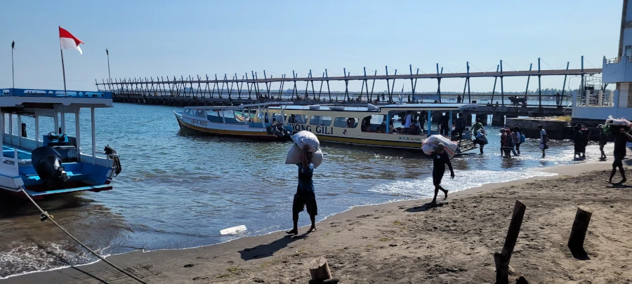 puerto de Bangsal en Lombok con barcos hacia las Islas Gili y locales cargando mercancía