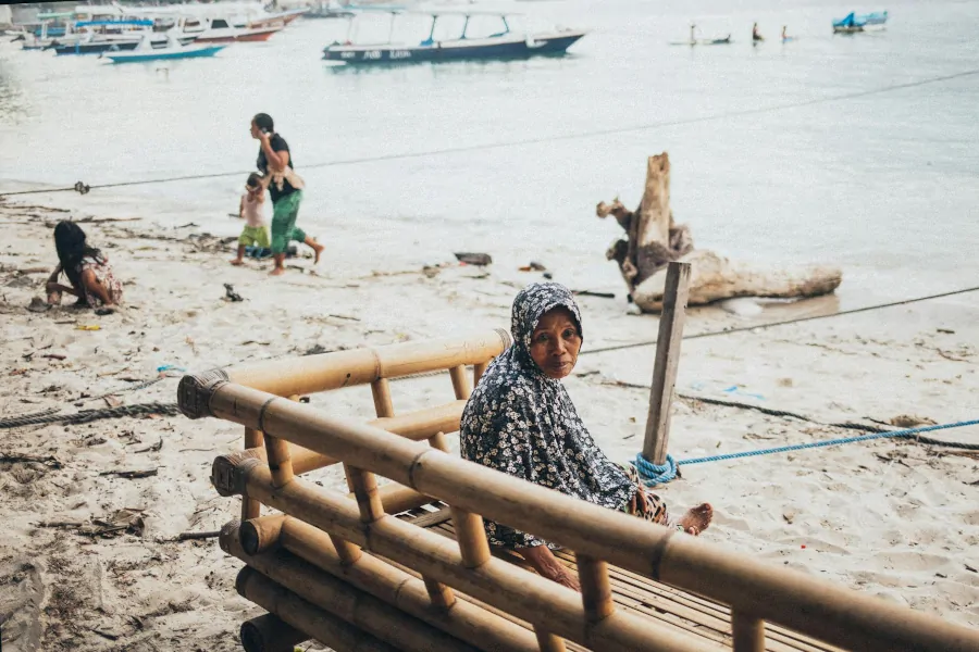 Mujer local en la playa de las Islas Gili en Indonesia con vestimenta tradicional