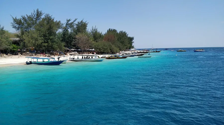 Playa en Gili Trawangan con agua turquesa y barcos en la orilla