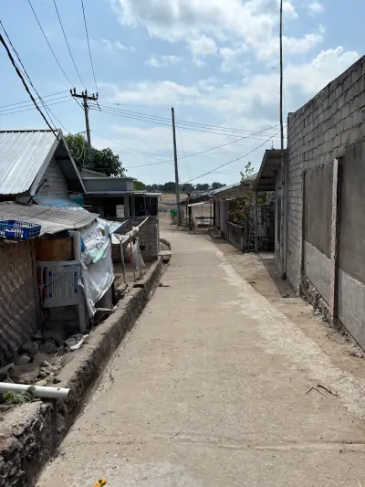 Calle de un pueblo local en Gili Gede con casas sencillas y sin infraestructura turística