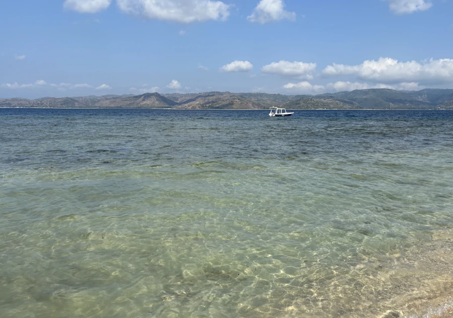 Playa de Gili Gede en Lombok con agua cristalina y vistas a la costa montañosa