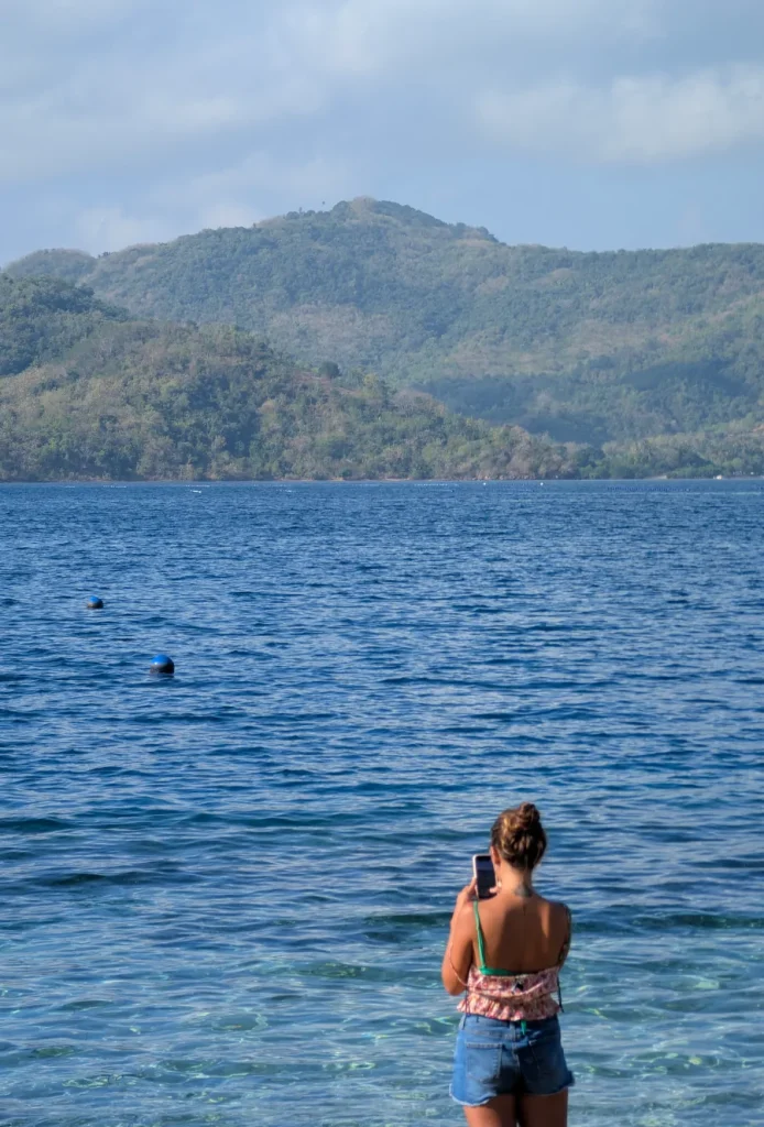 Mujer mirando el mar en Gili Gede con montañas de Lombok al fondo