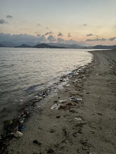 Playa de Gili Gede con basura y residuos en la orilla al atardecer