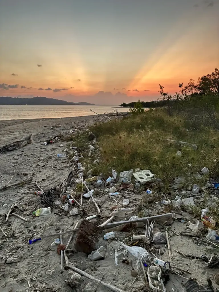 Atardecer en Gili Gede con basura y plásticos en la playa